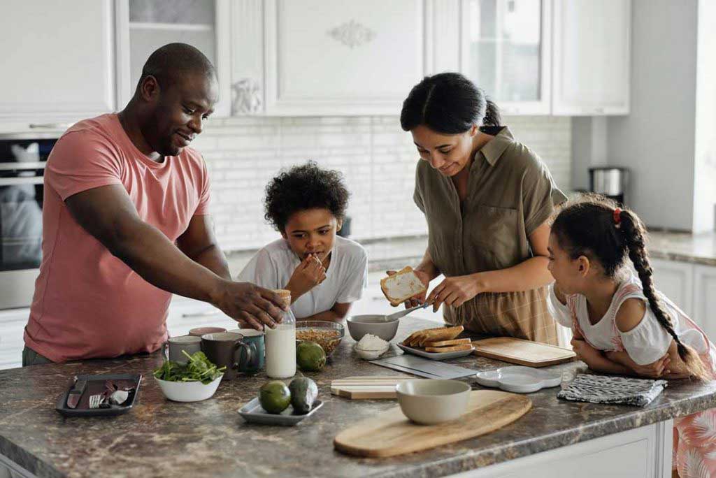 Picture of parents and kids cooking in their kitchen while having a staycation with kids in Raleigh