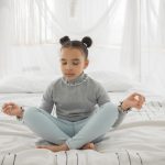 Picture of a young girl meditating for the blog benefits of yoga for kids