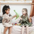 Picture of two preschool students sharing a dinosaur toy after a lesson on teaching sharing to preschoolers