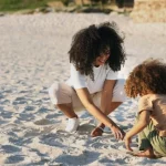 A mom and son play at the beach while following beach safety tips