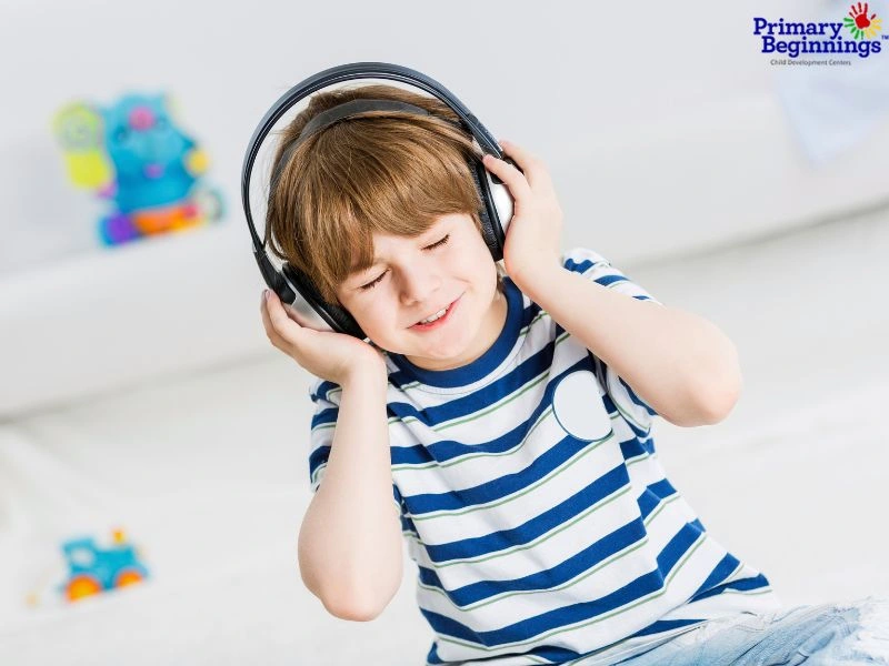 Child listening to music through headphone. This image goes with the blog about the benefits of music for preschoolers.