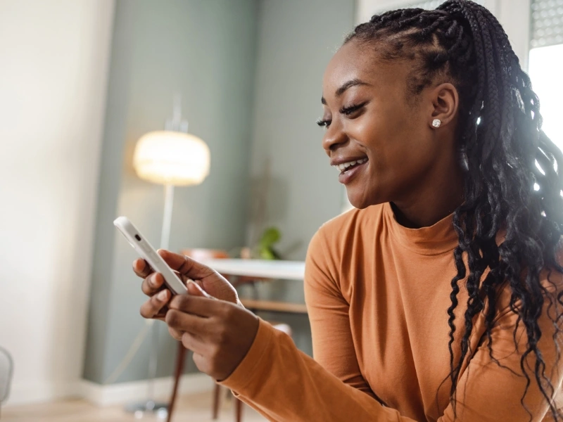 Mom on phone reviewing the complete back to school checklist for parents. 