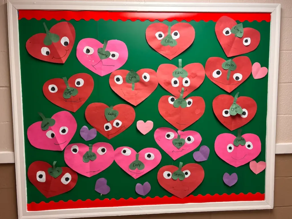 A classroom board with red and pink hearts meant to explain valentine's day