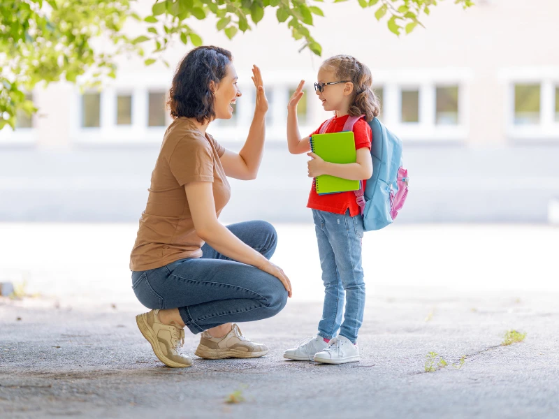 A mom and child high five, demonstrating she knows how to encourage kids to share