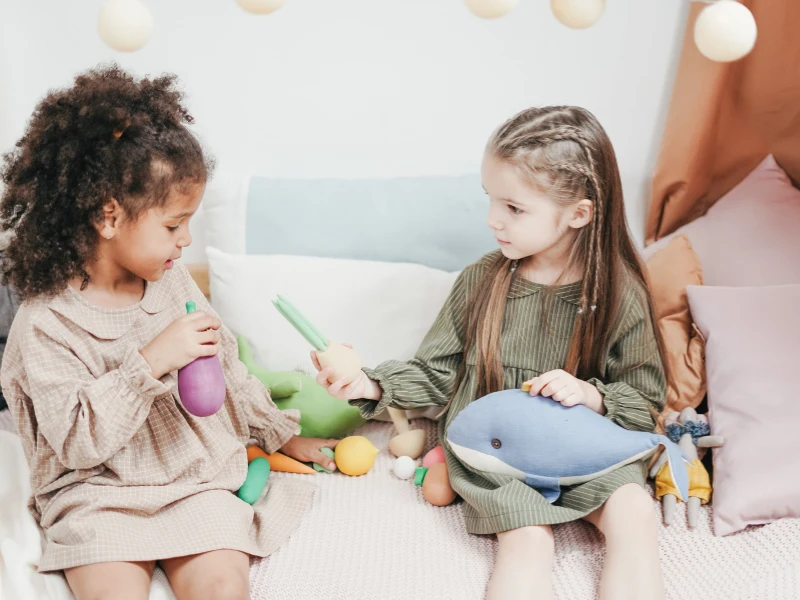 Toy girls playing with toys. Image highlights how to encourage kids to share toys