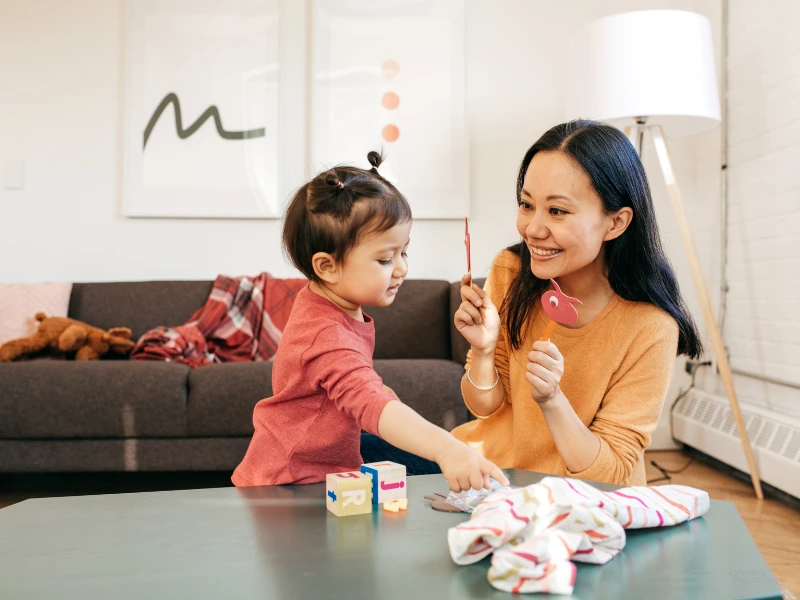 Mom and child playing. Image represents how to teach kids sharing