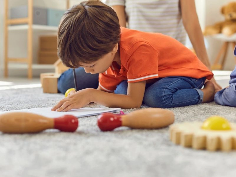 music for preschoolers for creativity as shown here by a young boy drawing.
