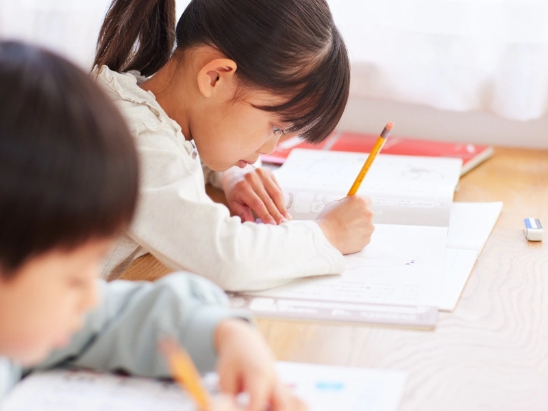 Child doing homework with a pencil and paper. This image complements the blog post titled Road Safety for Kids and preschool road safety worksheet. 