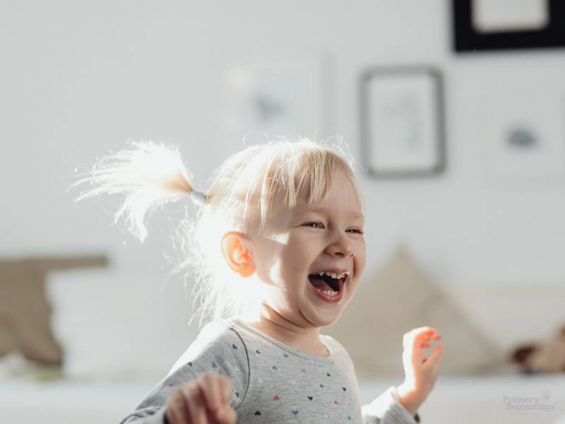 Young child laughing. Image accompanies the blog featuring preschool science experiments. 