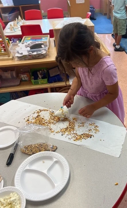 A child makes a birdfeeder to demonstrate problem solving in early childhood