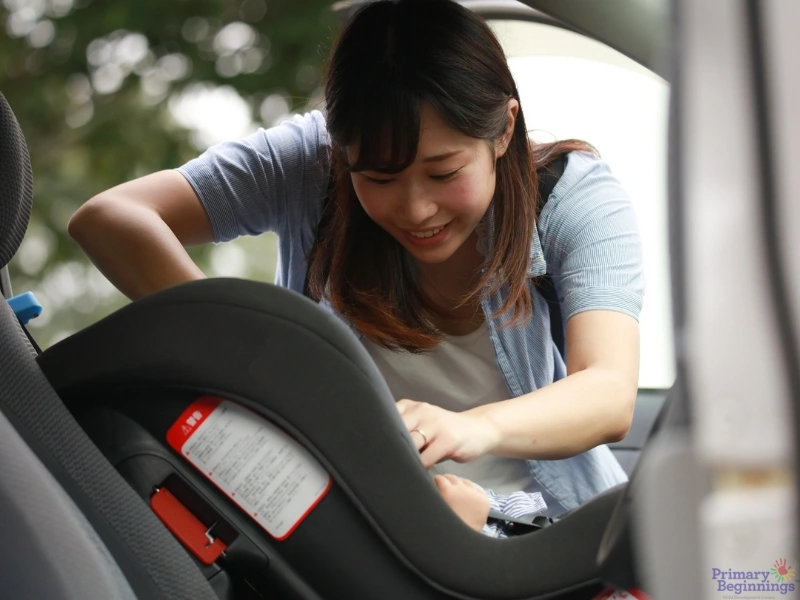 Mom fastens child in car seat. This image complements the blog post addressing road safety for kids and road safety rules for kids.