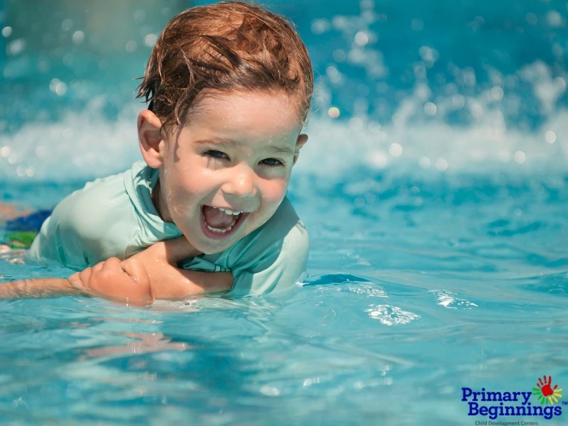 A young boy smiling in a pool. This image accompanies the blog titled, "Sports for Preschoolers."