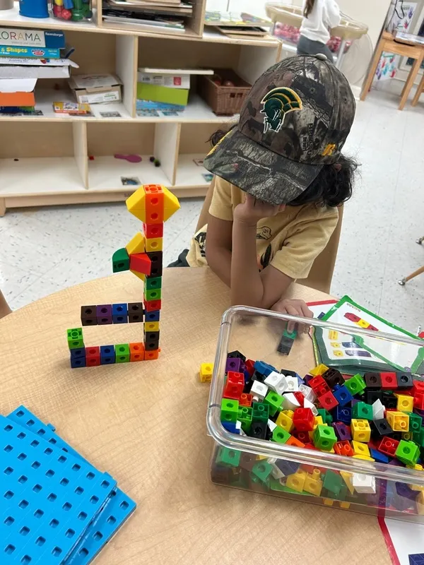 Child playing with legos. This demonstrates teaching problem solving skills to preschoolers using toys.